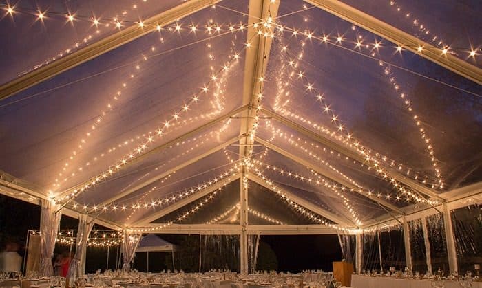 Clear tent reception with criss-crossed string lights, the look of the Modern Gala package