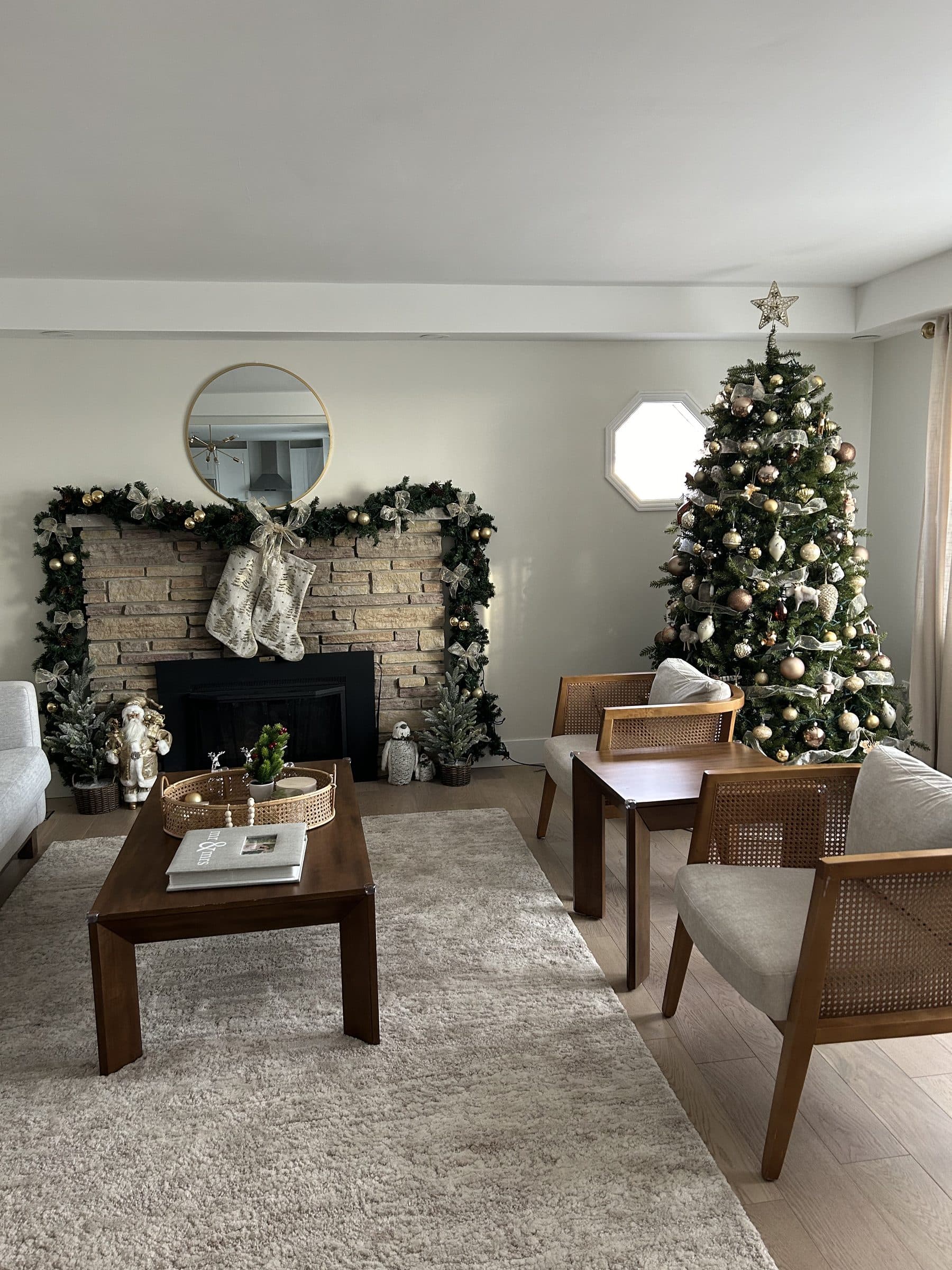 Decorated Christmas tree with a lit garland mantel and stockings in a living room