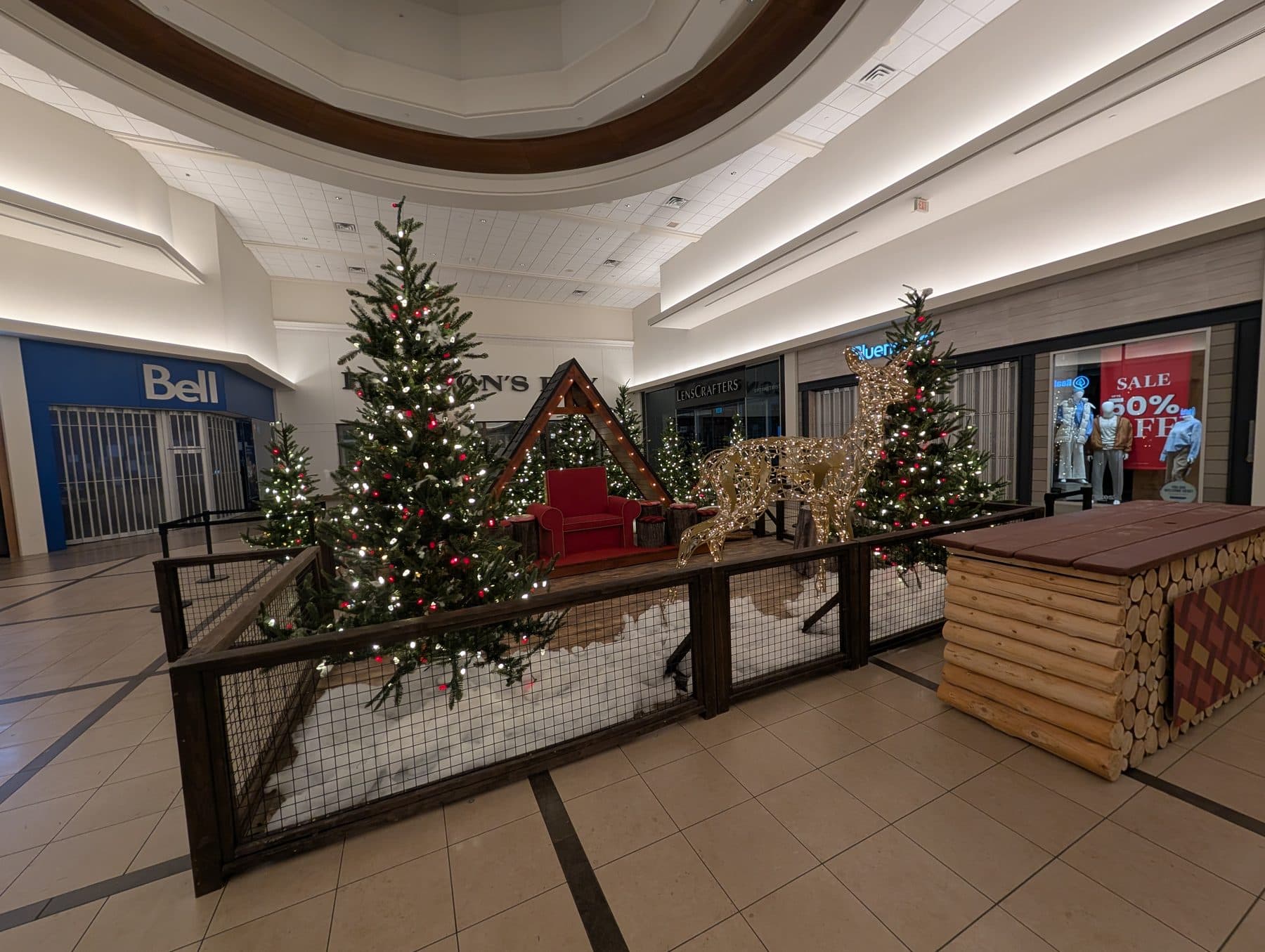Mall Christmas village display with lit trees and gold reindeer
