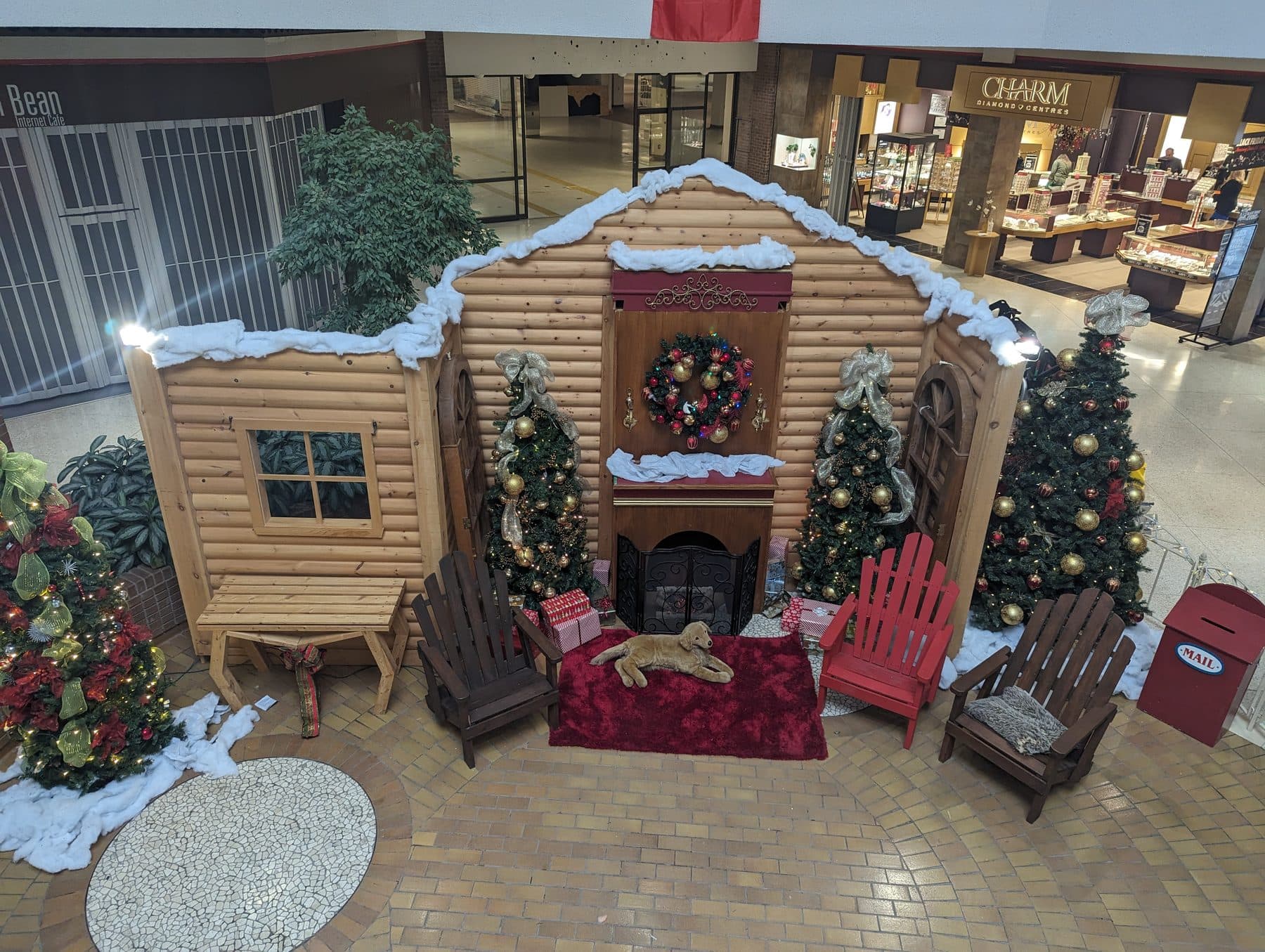 Santa photo set centrepiece with a log cabin facade and wreath in a mall