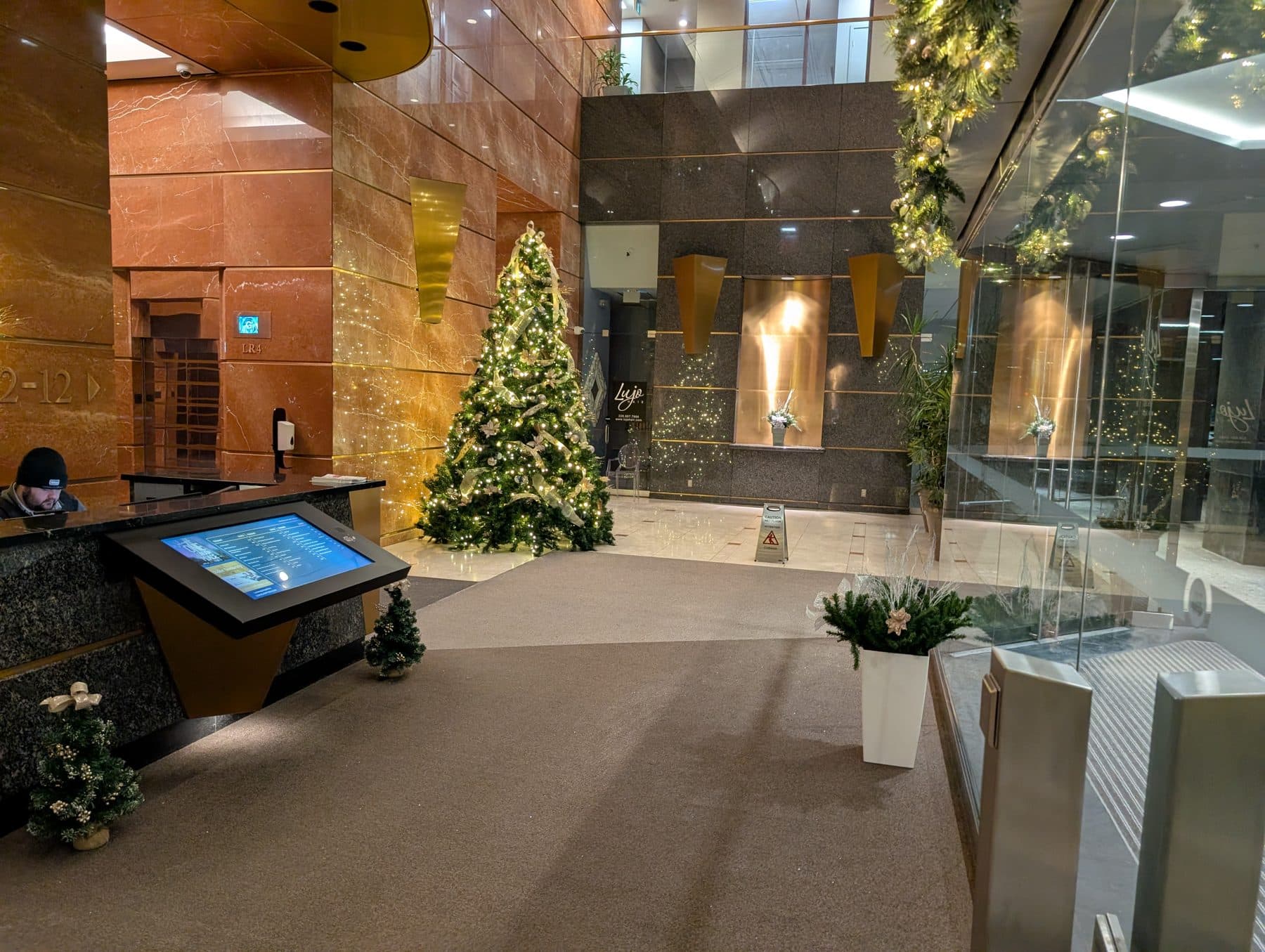Corporate lobby lit for an event with a decorated tree and garland