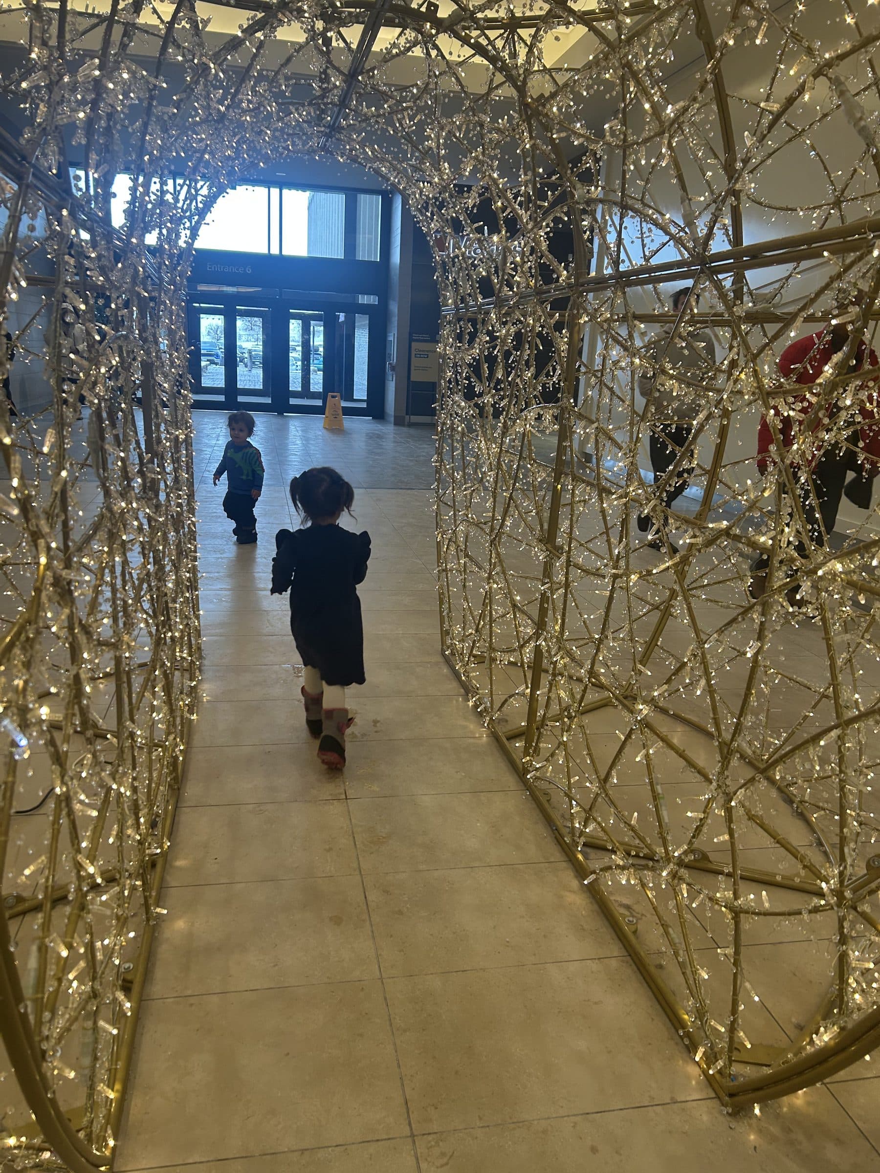 Walk-through tunnel of light arches in a commercial atrium, an example of gala production lighting