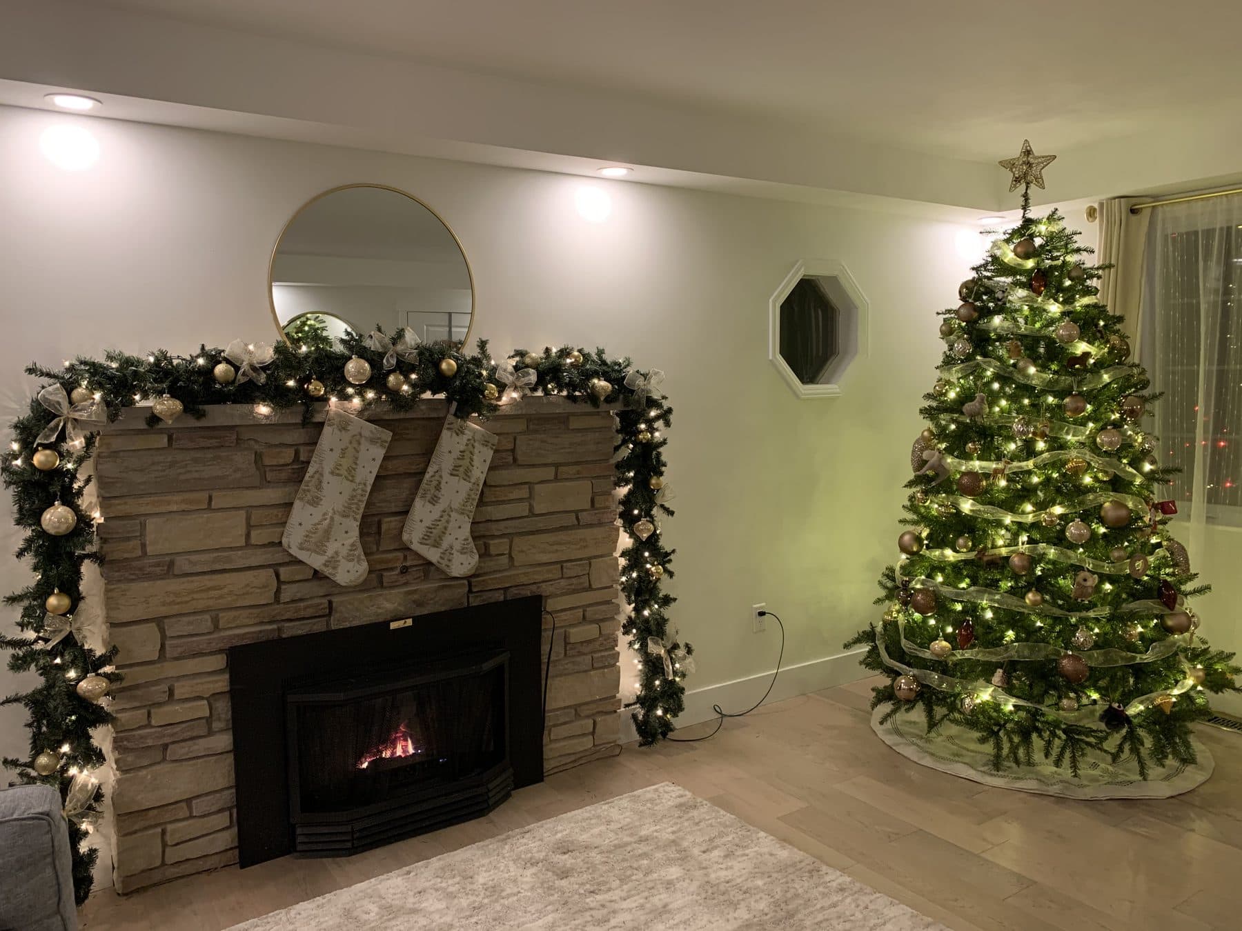 Stone fireplace with lit garland and stockings, the look of the Festive Glow package